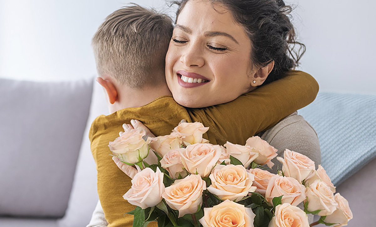 mom with gift roses hugging son